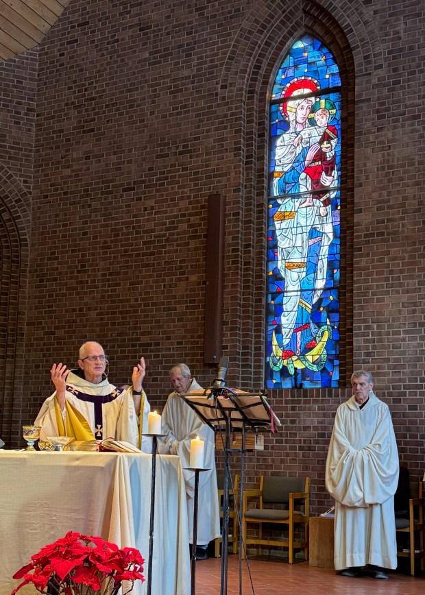 Under the Our Lady of Snowmass stained glass window, Fr. Charles Albanese celebrates the final Mass at St. Benedict's Monastery. (Photo courtesy of Monica Costello)